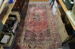 A Persian style rug, pink ground with stylised decoration 210cm x 112cm.