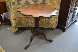 A mahogany tripod table with piecrust shaped top.