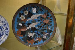 A Japanese cloisonne circular dish decorated with cranes in flight.