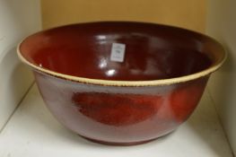 A large Chinese red glazed pottery bowl.
