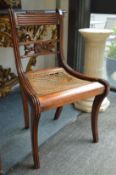 A Regency carved mahogany dining chair with cane work drop-in seat.