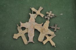 A bag of assorted bronze crosses.