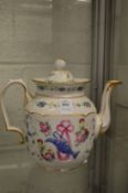 A porcelain teapot decorated with a ewer and ribbon amongst floral sprays.