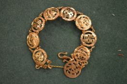 A Chinese yellow metal bracelet of pierced and engraved design.