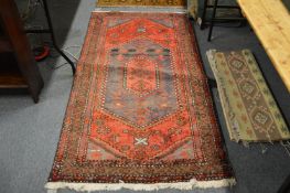 A Persian rug, red ground with stylised decoration (worn) 200cm x 105cm.