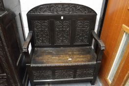 A carved oak hall settle.