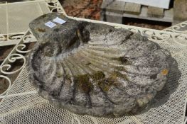A shell shaped bird bath top.