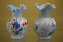 A pair of floral decorated opaque glass vases.