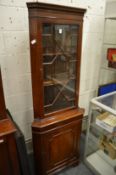 A reproduction mahogany standing corner cabinet.