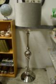 A large chrome floor standing lamp.