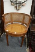 A French carved beech and canework upholstered tub shaped armchair.