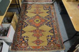 A Kazak rug, beige ground with stylised geometric motifs decorated with animals 180cm x 120cm.
