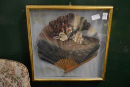 A decoratively painted fan, framed and glazed.