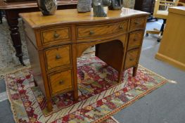 A satinwood and inlaid serpentine fronted kneehole desk or dressing table.
