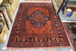 A modern Persian design carpet, claret ground with stylised decoration depicting vases and other