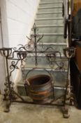 An ornate wrought iron cooking pot stand complete with cooking pot.