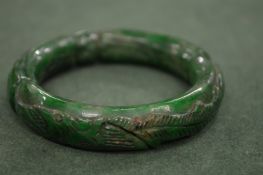 A Chinese carved jadeite bangle.