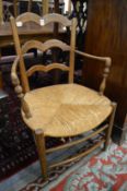 A French ash and rush seated ladder back armchair.