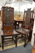 A pair of carved oak high back hall chairs.