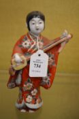 A Japanese pottery model of a musician.