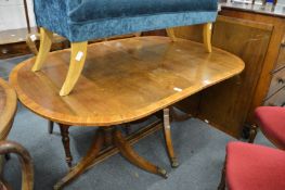 A George III design mahogany and rosewood banded twin pedestal dining table with two leaves.