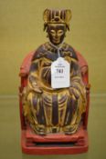 A Chinese carved, gilded, and lacquered carved wood seated figure.