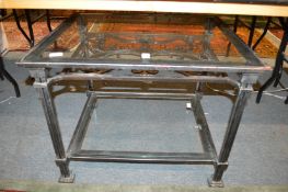 A wrought iron and glass two tier coffee table.