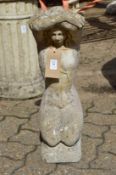 A composite garden ornament modelled as a kneeling female figure.