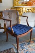 A mahogany elbow chair with cane work back and seat.