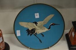 A Japanese cloisonne dish decorated with a crane in flight.