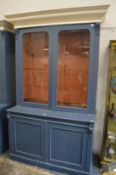 A blue painted cupboard bookcase.