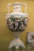 A pair of large Capodimonte urn shaped twin handled vases on pedestal bases.