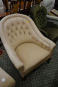 A button upholstered horseshoe shaped armchair.