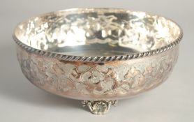 A CONTINENTAL SILVER PLATED BOWL with floral repousse decoration supported on three shell feet. 9.