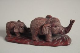 A JAPANESE CARVED WOOD ELEPHANT AND YOUNG. Signed, 4.5ins long.