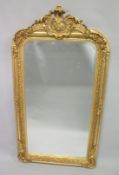 A GILT ROCOCO UPRIGHT MIRROR. 5ft 2ins x 2ft 7ins.