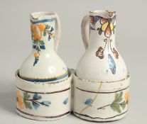 AN 18TH CENTURY TIN GLAZE CRUET with two jugs and a carrying handle. 4.5ins high.