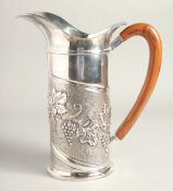 A LARGE FRENCH CESELLATO A MANO 0925 SILVER JUG, repousse with fruiting vines, with wooden