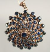 A 14CT GOLD SAPPHIRE SWIRL BROOCH-PENDANT.