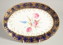 A GOOD OVAL DISH with blue and gilt border and painted with flowers. 11ins wide.