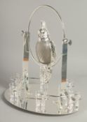 A SILVER PLATED COCKTAIL SET as a parrot on a perch, six glasses on an oval base. 15ins high.