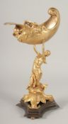 A GILT BRONZE COMPORT, a lady holding a shell on a triangular base. 1ft 3ins high.