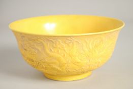A CHINESE FAMILLE JAUNE CIRCULAR RICE BOWL, dragons in relief.