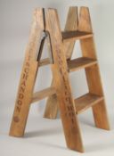 A DOM PERIGNON SET OF FOLDING STEPS. 2ft 10ins high.