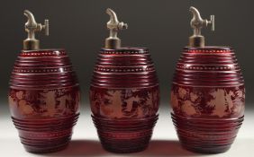 A SET OF THREE BOHEMIAN RUBY GLASS BARRELS engraved with deer and dogs, with chrome tops.
