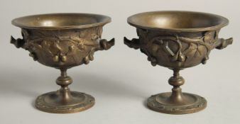 A SMALL PAIR OF GRAND TOUR BRONZE CIRCULAR URNS. 4.5ins diameter.