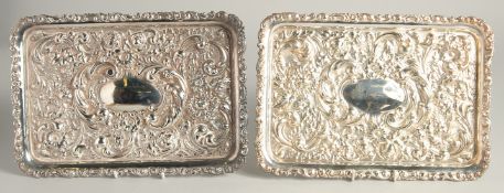 A PAIR OF VICTORIAN STYLE RECTANGULAR DISHES with repousse decoration. 11ins x 7.5ins.