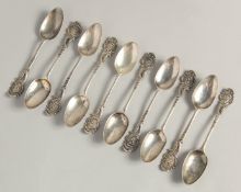 A SET OF TEN GEORGE II PICTURE BACK SILVER TEASPOONS with cast classical head finials.