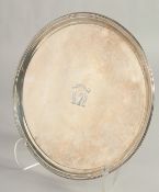 A GEORGE III SILVER CIRCULAR SALVER, 9.5ins diameter, with reeded edge and crest. London 1795, maker