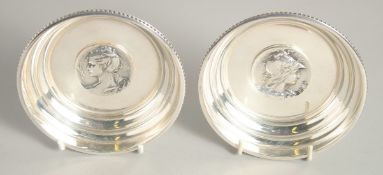 A SMALL PAIR OF SILVER PLATED CIRCULAR DISHES with cast handles. 4.25ins diameter.